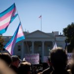 Trans flag flying in crowd in front of the White House